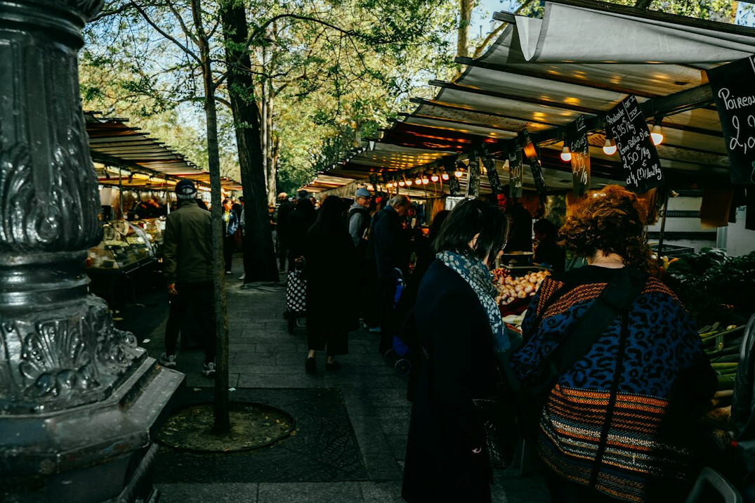 People waiting in line at an outdoor food market stall
