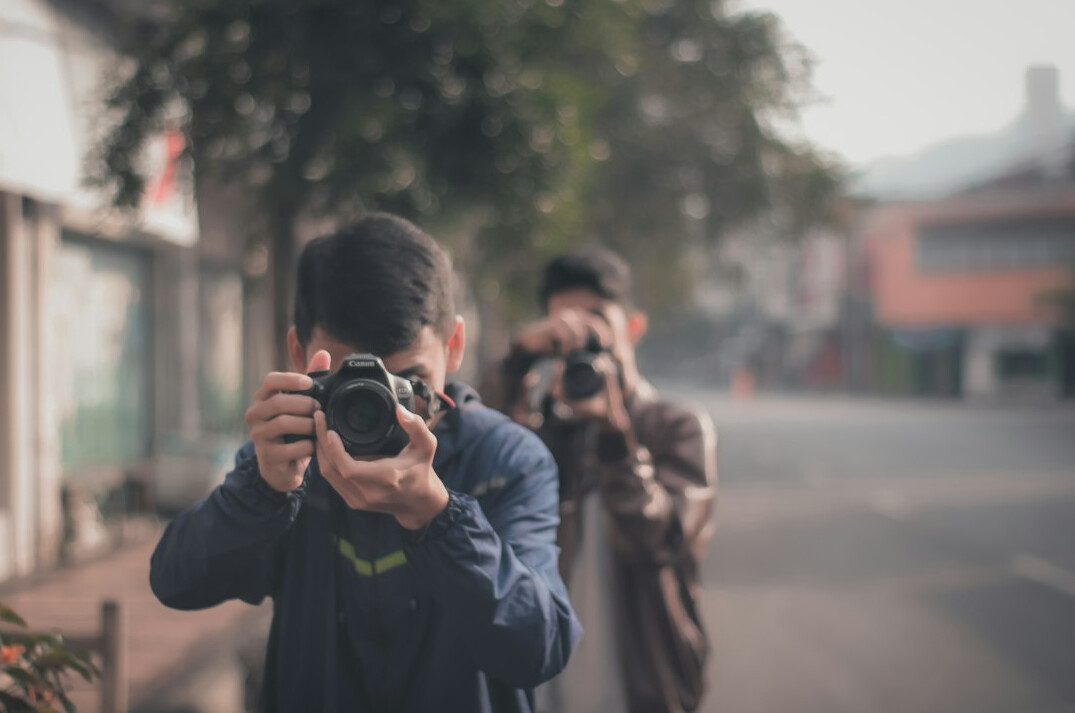 Small team of journalists and photographers reviewing photos together